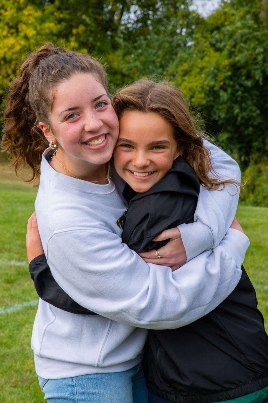 Soarin, New Life's Eagle Mascot, posing with two young boy students outside the main doors of NLA.