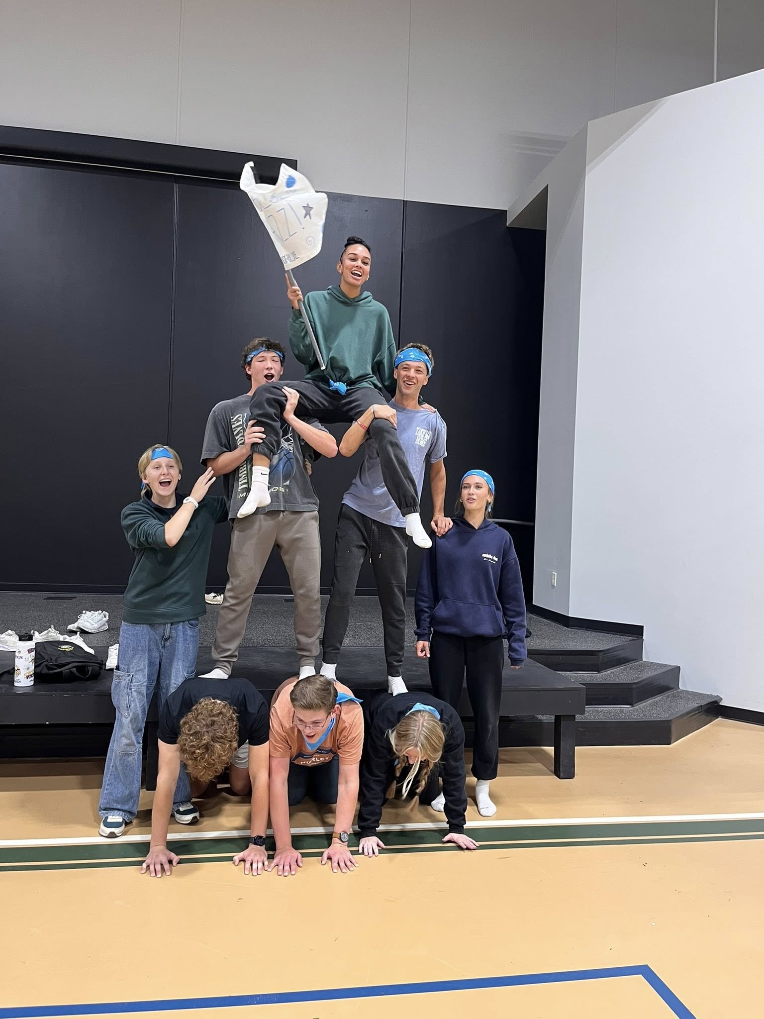 New Life Academy senior hitting a baseball with a bat during the Home Run Derby at the Senior Retreat, highlighting athletic energy and school spirit.