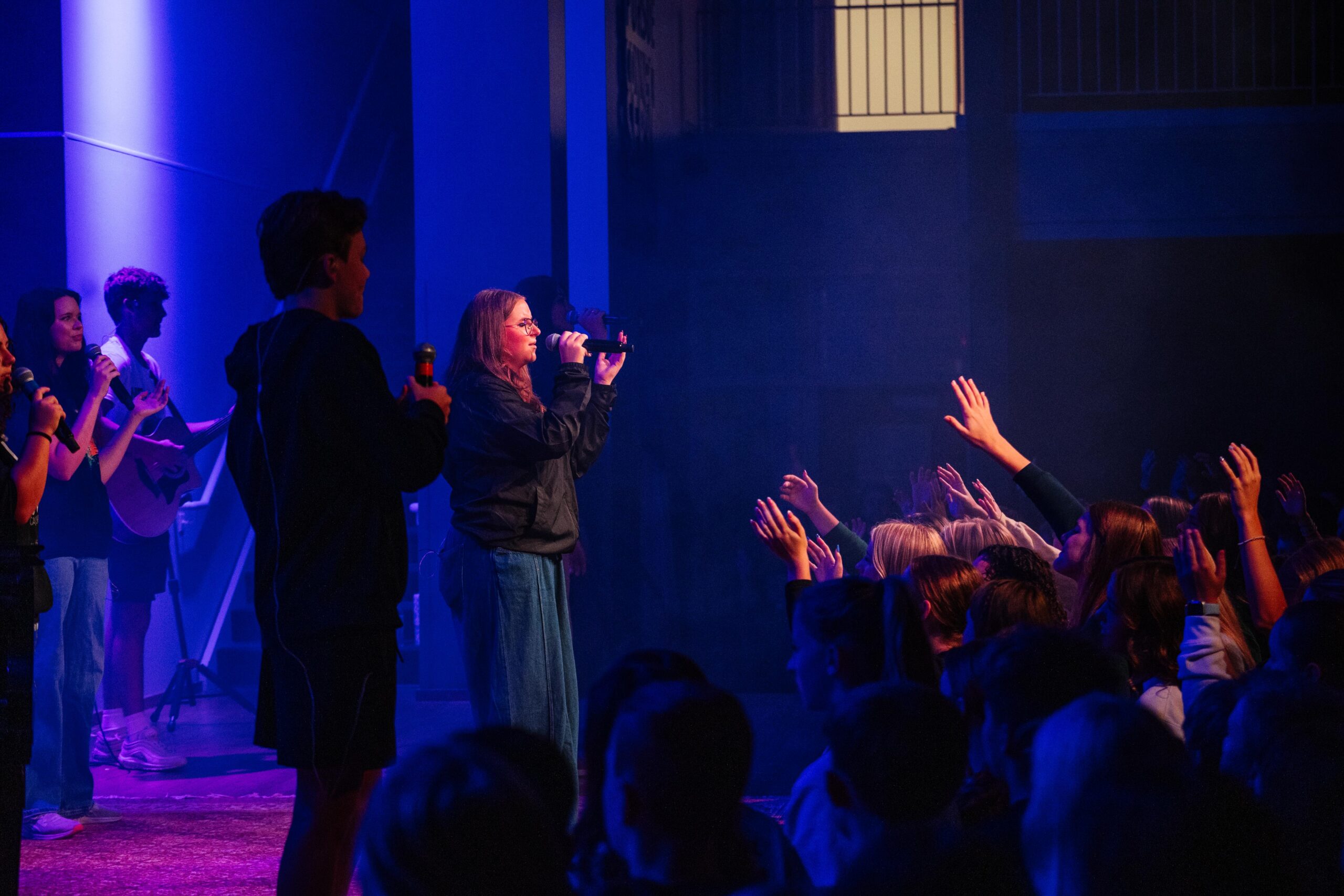 Upper school student participating in chapel worship at New Life Academy