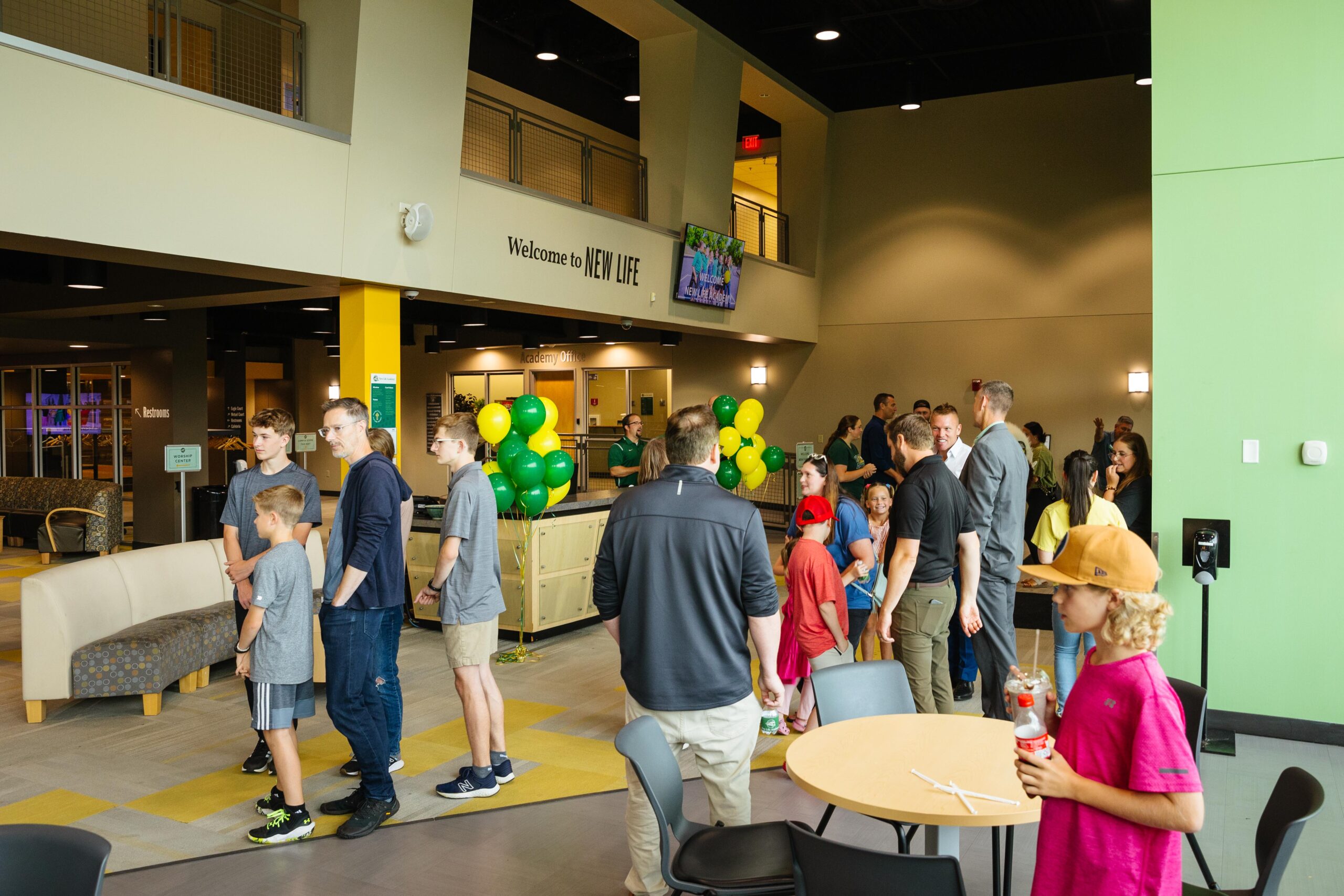 Speaker addressing families during New Life Academy’s New Family Orientation in an auditorium with attendees seated.