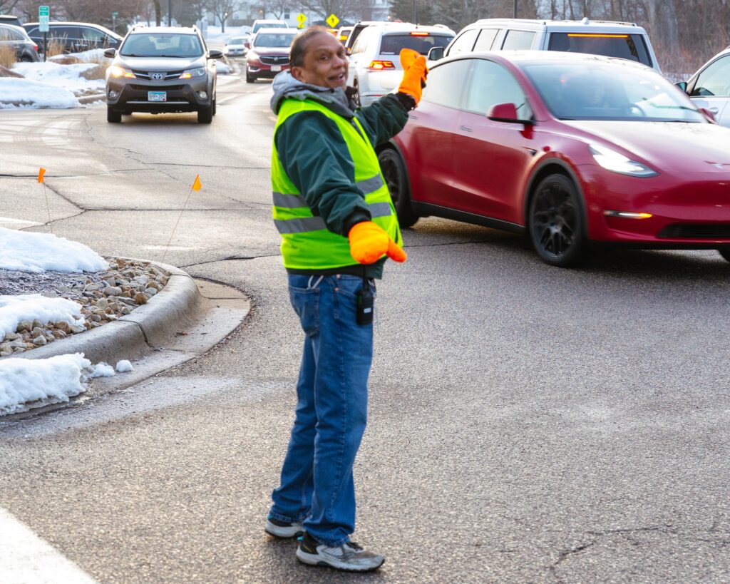Orlando Harpial directs morning traffic outside New Life Academy.