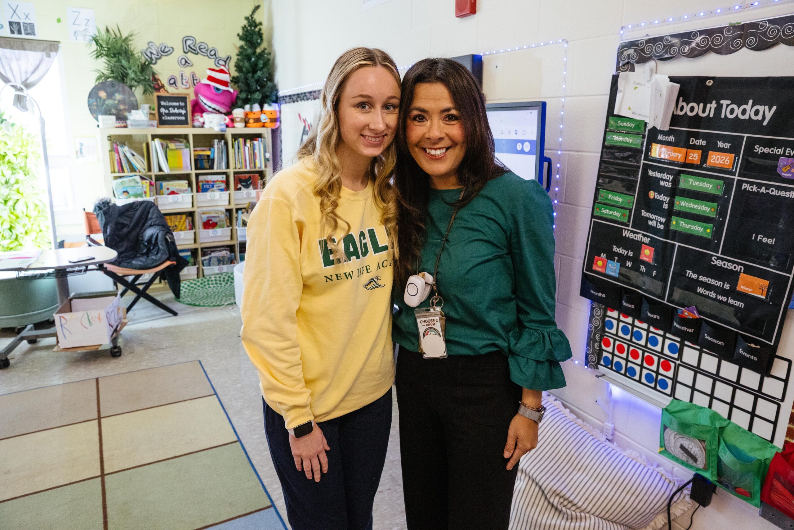 Senior Teaching Assistant Kayden and Kindergarten teacher Monica Doherty standing together in a New Life Academy classroom.