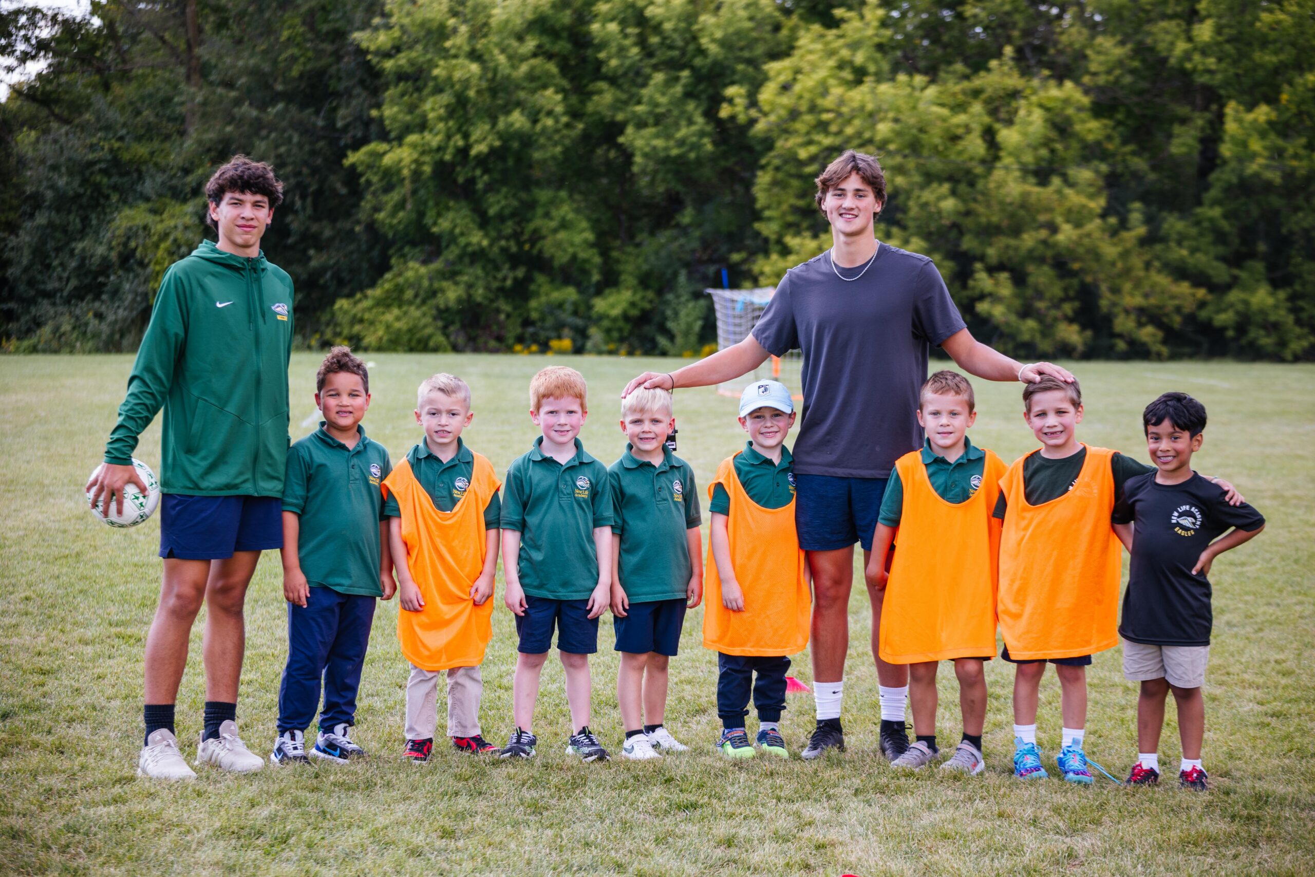 New Life Academy Junior Eagles soccer program with high school athletes mentoring elementary students on the field