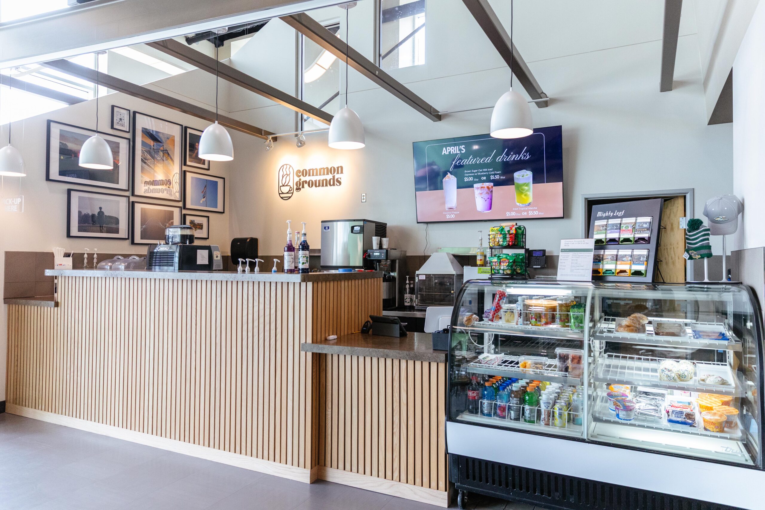 Common Grounds school coffee shop updated with Annual Fund support featuring modern counter, student artwork, new lighting, and digital signage.